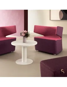 Table basse ronde blanche au centre d’un espace lounge