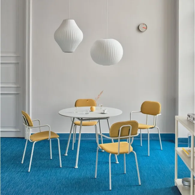 Table ronde blanche entourée de chaises jaunes