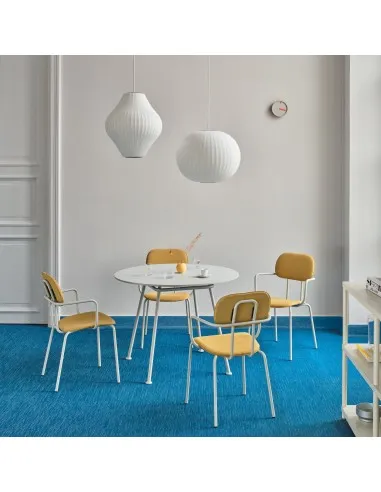 Table ronde blanche entourée de chaises jaunes